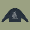 A navy blue cropped sweatshirt featuring a white line art graphic of an owl on the chest, with white script text printed on both sleeves, displayed against a solid white background.