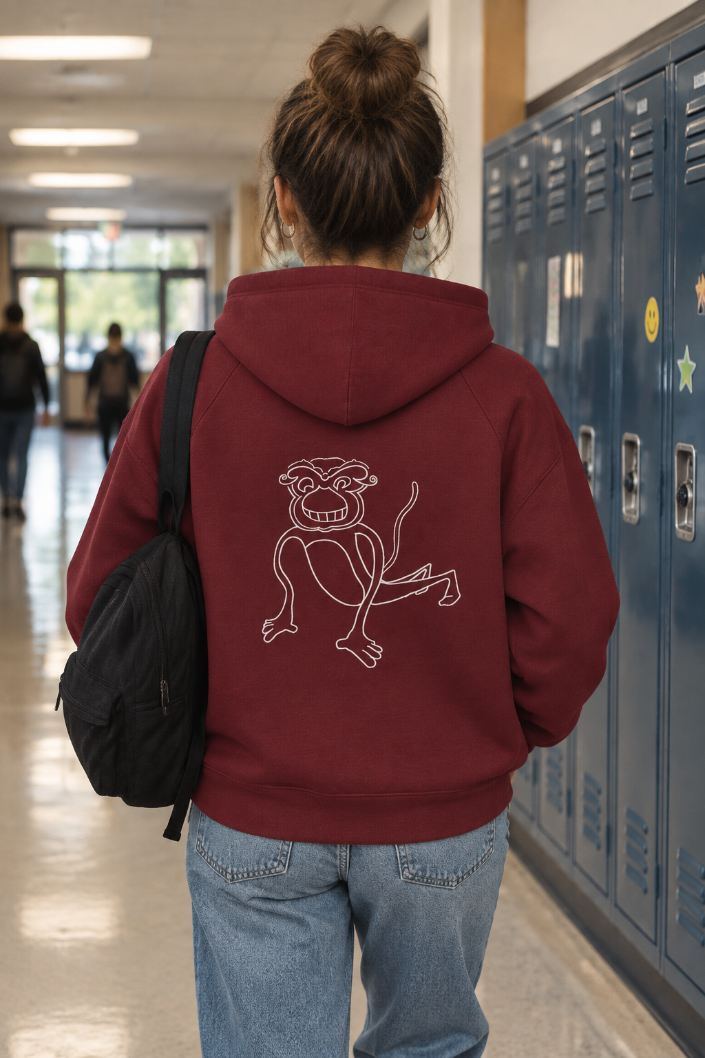 A maroon hoodie shown from the back, featuring a white line art graphic of a cartoon monkey on the center back, set against a plain white background.