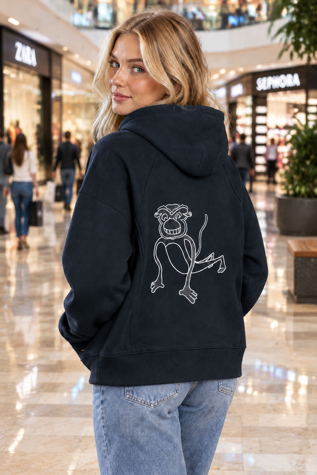A maroon hoodie shown from the back, featuring a white line art graphic of a cartoon monkey on the center back, set against a plain white background.